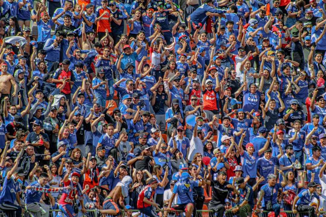 Football supporters packed into stadium stands, united in emotion
